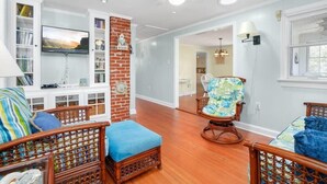 Una sala de estar con chimenea, muebles de madera y un televisor montado en la pared.