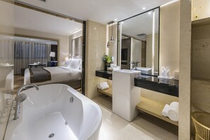 A modern hotel bathroom with a large bathtub, a vanity with a mirror, and a separate bedroom area with a bed and a desk. - Best Western Plus Haiyue Hotel Fuzhou (Fuzhou)