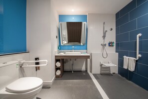 Un baño moderno con inodoro, lavamanos y ducha.
