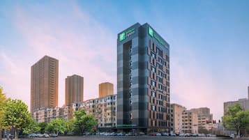 A Holiday Inn Express building with a modern design, surrounded by other high-rise buildings.