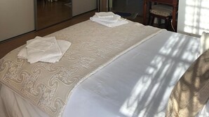 Une chambre d’hôtel avec un grand lit, un miroir, un bureau et une chaise.