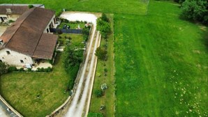 Vue aérienne d’une propriété comprenant un grand bâtiment, une allée et une pelouse bien entretenue.