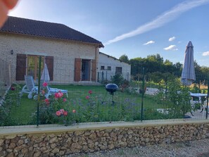 A stone house with a garden, outdoor seating, and a barbecue grill. - Chez Lucia near Périgueux (Église-Neuve-de-Vergt)