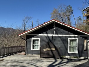A two-story building with a dark exterior and a red roof. There is a wooden sign at the entrance that reads "Welcome to Jayestie City Retreat."