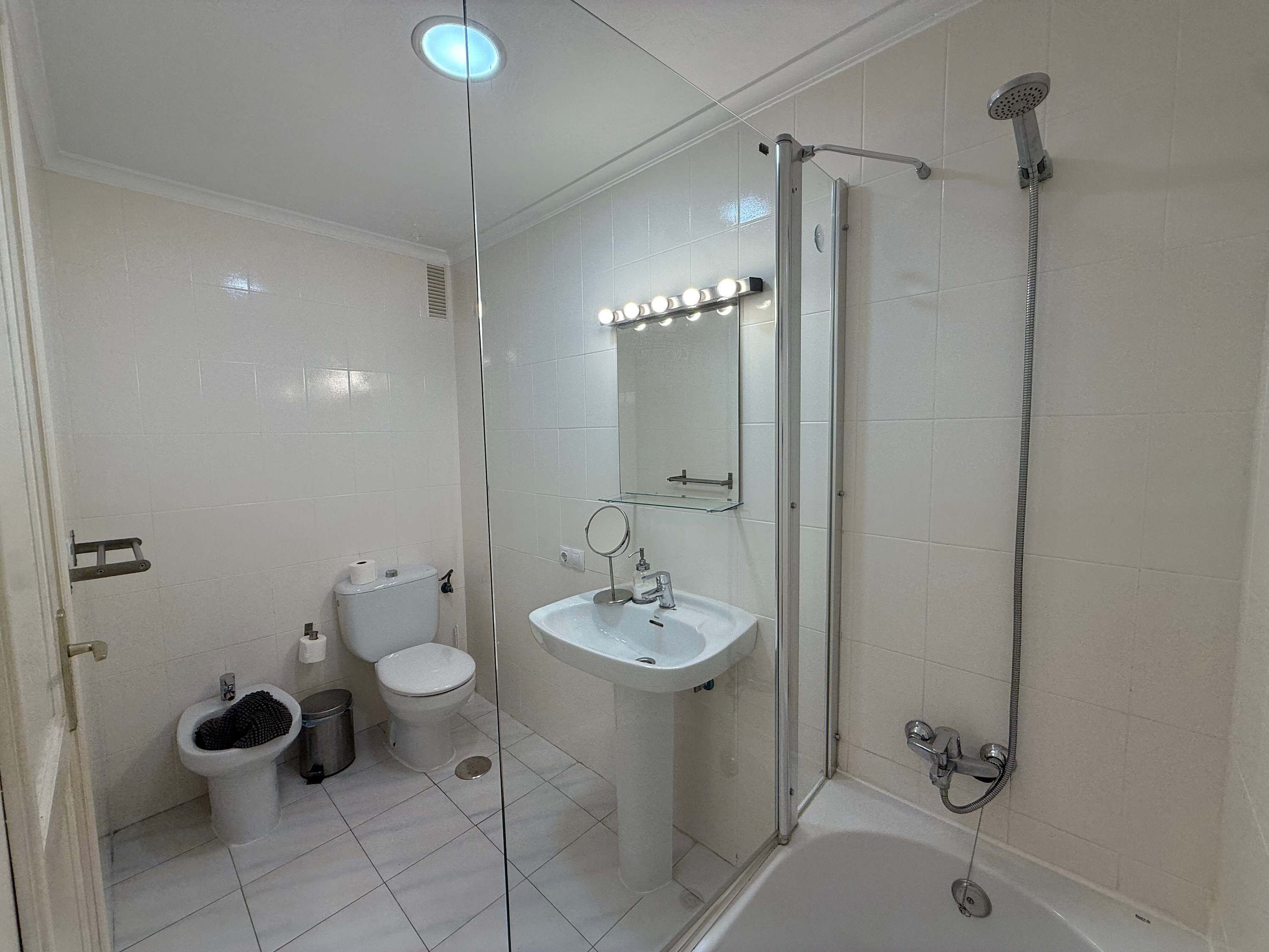 Bany amb vàter, bidet, rentapel i plat de dutxa.