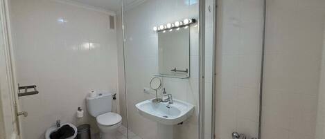 Bany amb vàter, bidet, rentapel i plat de dutxa.