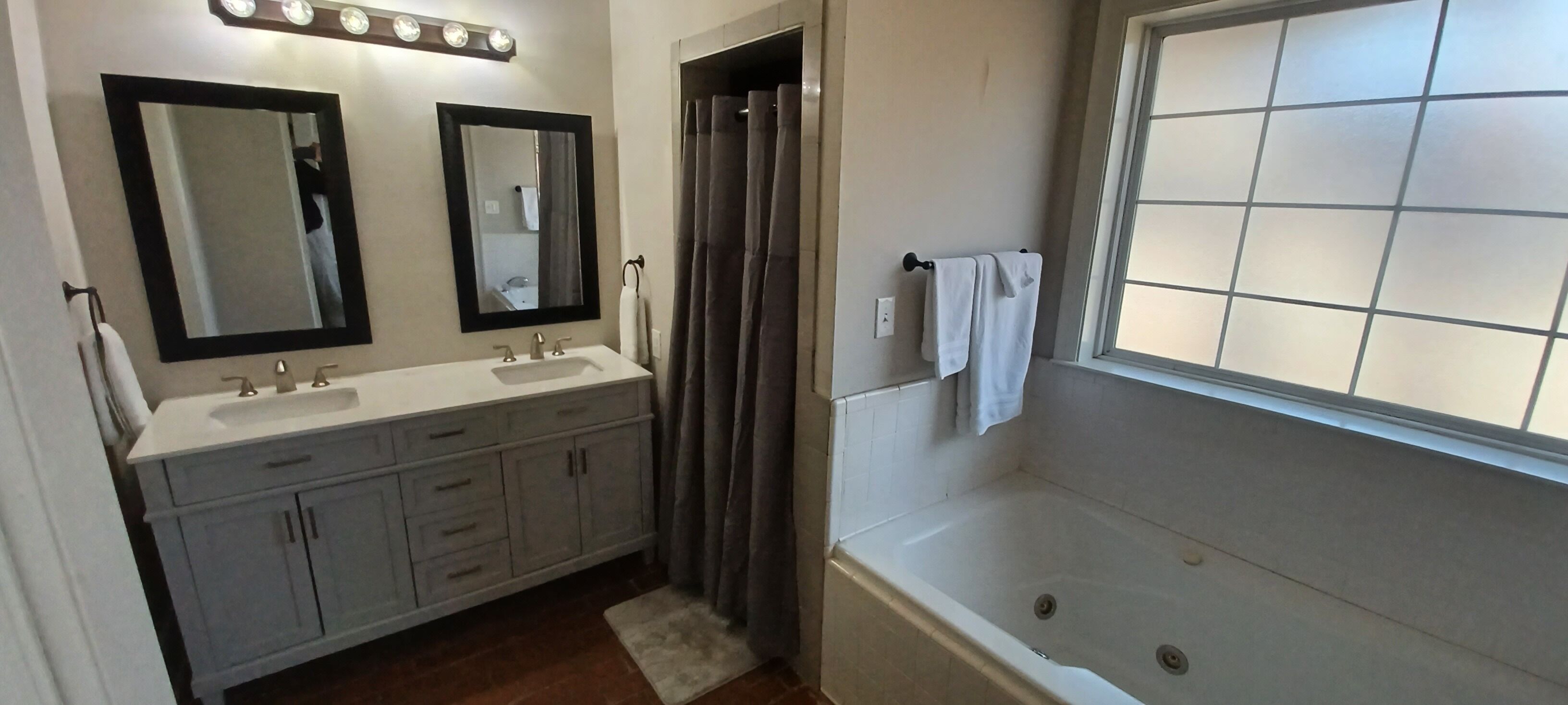 Un bagno con due lavandini, una vasca e una doccia.