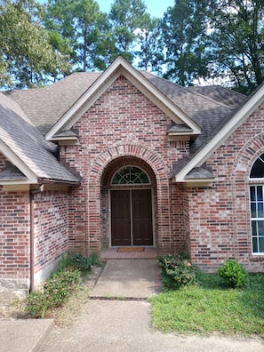 Stunning residential building with a symmetrical design, featuring a large double door and arched entryway.