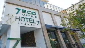 The exterior of the 7 Eco Office Hotel, featuring a modern facade with large signage, a staircase leading to the entrance, and a glass door. - Hotel 7 Itajaí by RB Hotelaria (Itajai)