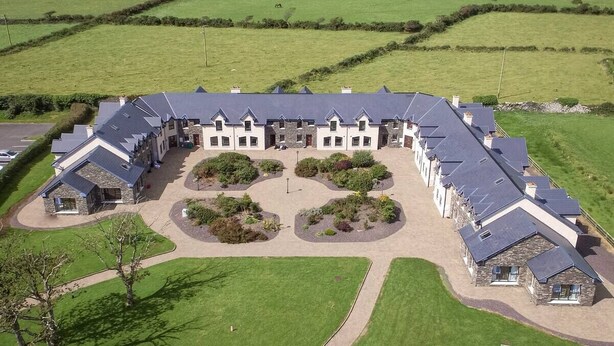 A large, rectangular building with a symmetrical layout, surrounded by well-maintained lawns and gardens. - House 3 Dingle Manor Remarkable 3-Bed House (Dingle)