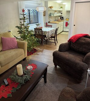 A living room with a Christmas tree, a sofa, a coffee table with decorations, and a dining area with a table and chairs. - 	
Tranquil Forest Escape-Extended Stays Welcome  (Oregon City)