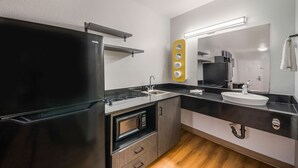 A compact kitchen with a black refrigerator, a microwave, a sink, and a small countertop. - Studio 6 Laredo, TX - North I-35 (Laredo)