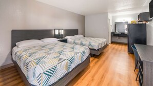 A hotel room with two beds, a desk, a mirror, and a TV. - Studio 6 Laredo, TX - North I-35 (Laredo)