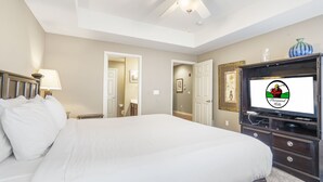 A bedroom with a bed, a ceiling fan, a TV, and a dresser. - Branson Townhome Near Hwy 76 | Pool | Garage | Sleeps 8 (Branson)