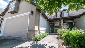 A two-story house with a garage, a front door, and a small porch area. - Branson Townhome Near Hwy 76 | Pool | Garage | Sleeps 8 (Branson)