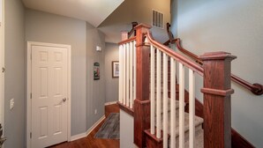 A staircase with wooden railings and a carpeted landing. - Branson Townhome Near Hwy 76 | Pool | Garage | Sleeps 8 (Branson)