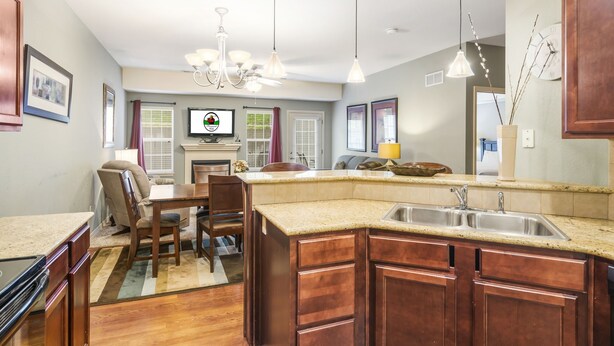 A kitchen with wooden cabinets, a granite countertop, a built-in sink, and pendant lighting. - Branson Townhome Near Hwy 76 | Pool | Garage | Sleeps 8 (Branson)