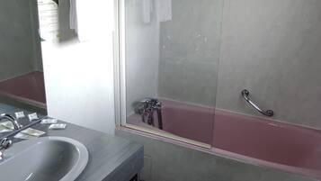 A bathroom with a sink, mirror, and a bathtub.