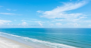 Una playa con cielos despejados y aguas tranquilas.