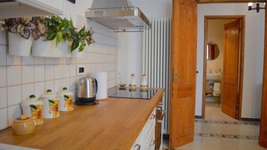 Eine Küche mit Holzausziehtisch, einem Wasserkocher und einer Heizung.