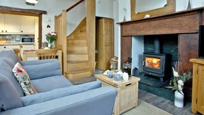 Un salon chaleureux avec un canapé, une table basse en bois et une cheminée.