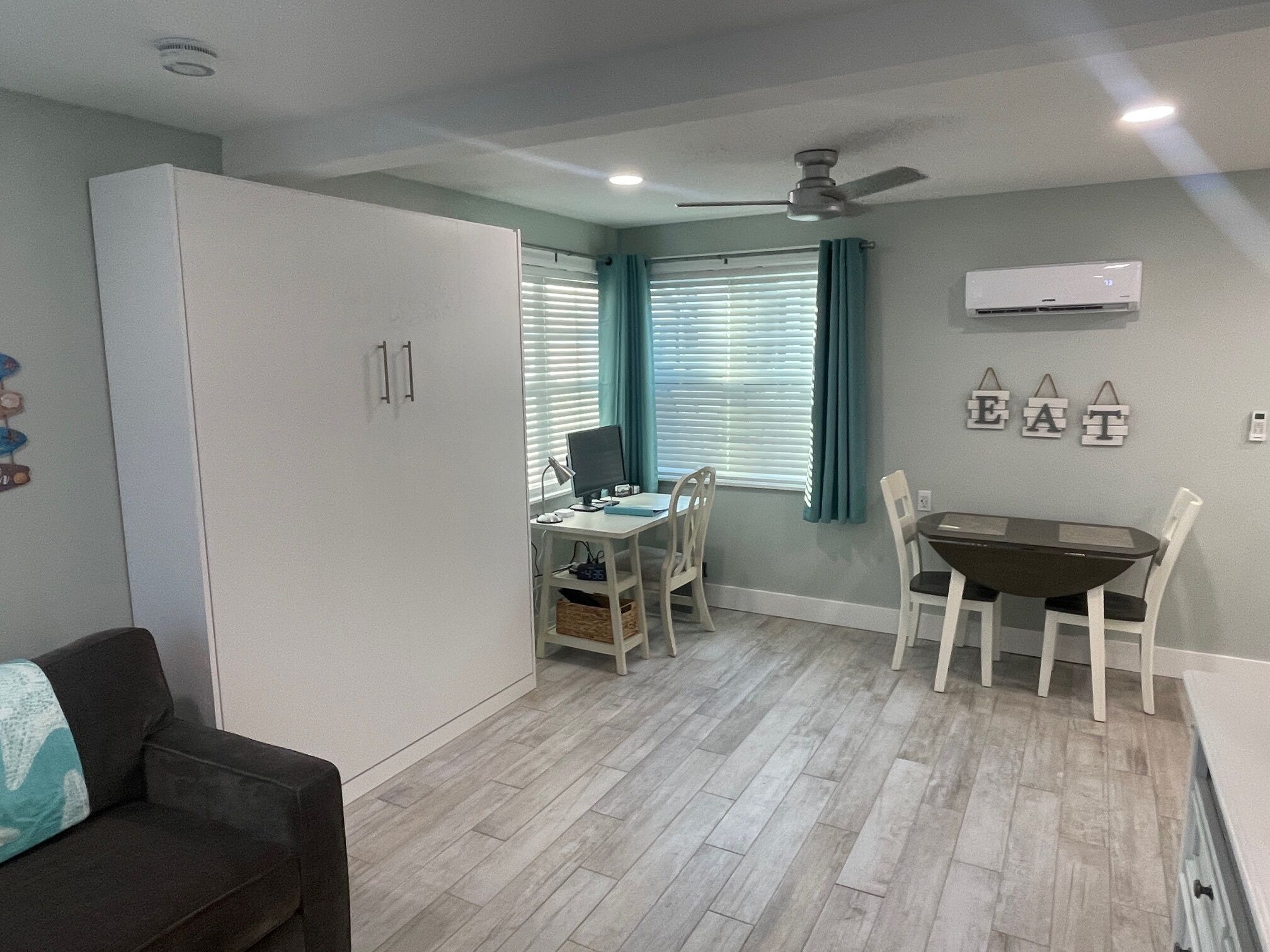 A compact living space with a kitchenette, a dining area, and a seating area.