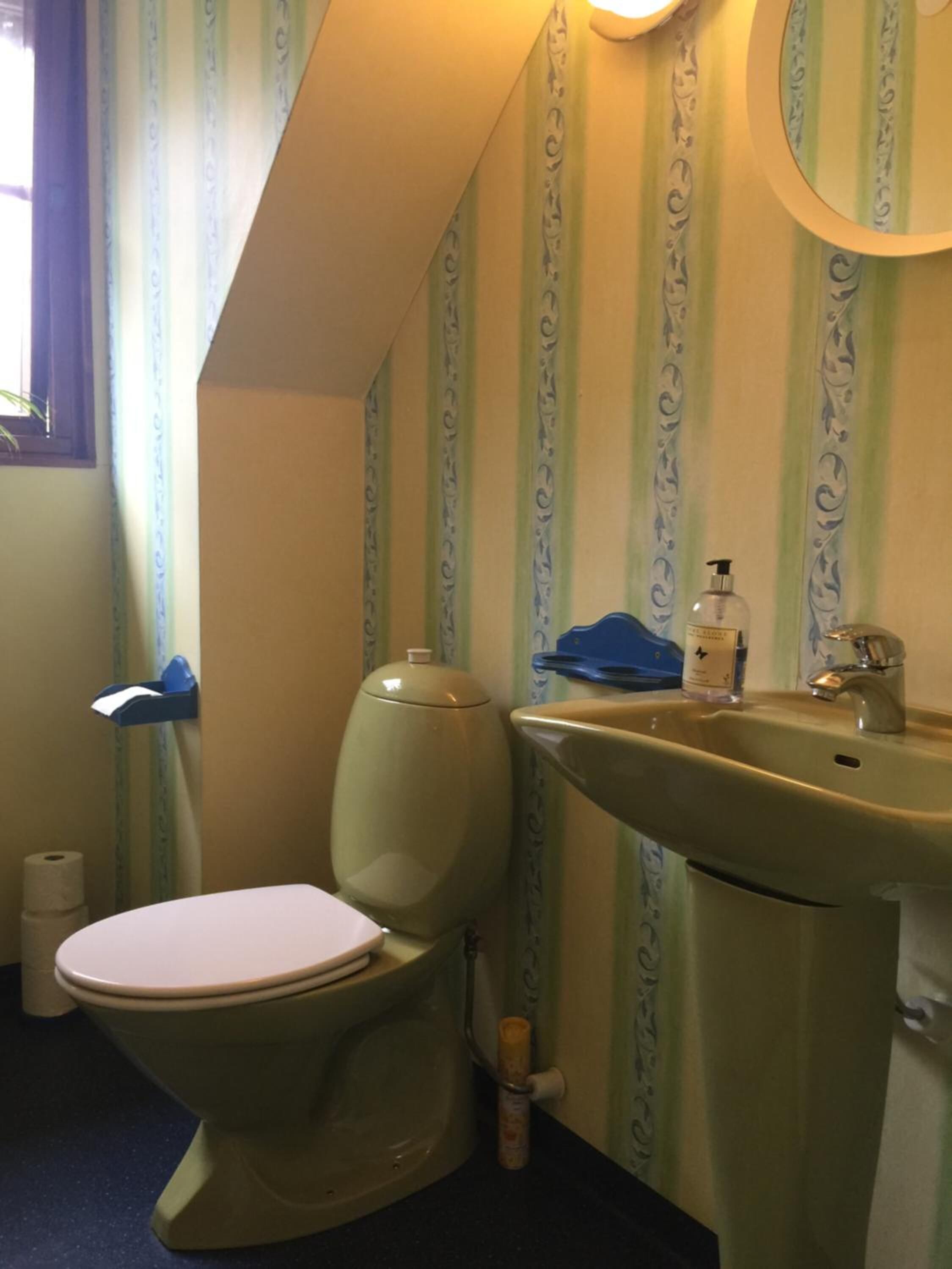 Un baño con inodoro, lavabo y ventana.