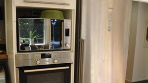 Una cocina equipada con microondas, horno y refrigerador de acero inoxidable.