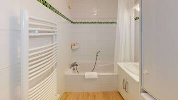 Bathtub, hair dryer, towels, toilet paper