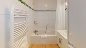 Bathtub, hair dryer, towels, toilet paper