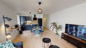 A modern apartment with a dining area, kitchen, and living space.