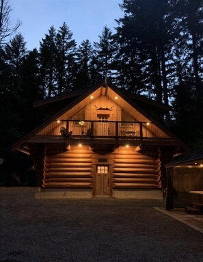 A log cabin with a balcony, a wooden door, and a small porch area. - Aspen Cabin (Packwood)