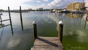 A marina with docked boats, a wooden pier with bollards, and a hotel in the background.