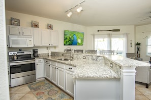 Enjoy cooking in this well-equipped kitchen with a large island, microwave, oven, and coffee maker.