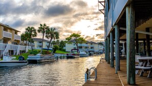 A waterfront hotel with a wooden deck, boats docked, and a view of the marina.