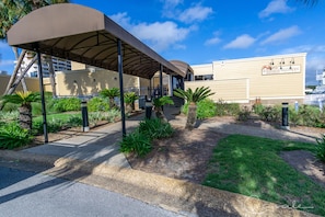 Step into the serene outdoor seating area adjacent to Bonterra Restaurant, surrounded by lush landscaping and a pathway leading to a cozy covered space.