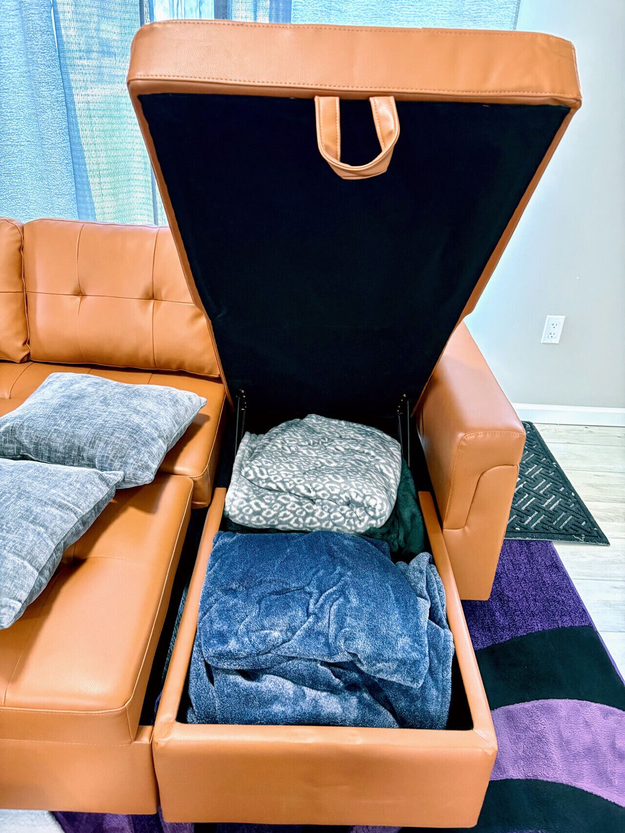 A brown leather sofa with a storage compartment underneath.