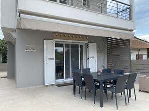 Ein modernes, zweistöckiges Gebäude mit Balkon, einer Willkommensschild und einem Schild für die Schuhaufbewahrung.