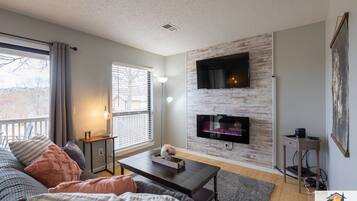 A modern living room with a sofa, coffee table, and a fireplace.