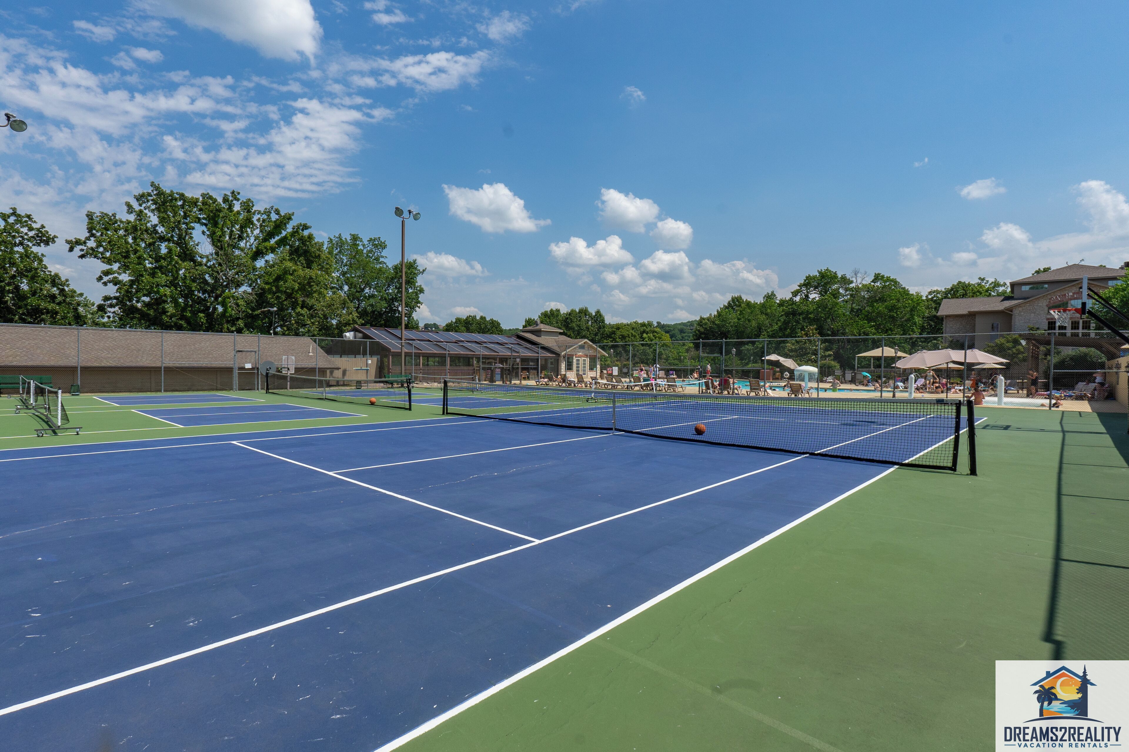 Pistas de tenis múltiples, una red y vallas perimetrales.