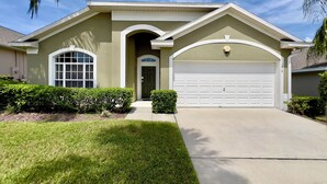 A single-story house with a garage, a front door, and a large window. - Private Pool & Spa • Game Room • 2 King Ensuites • 15 Minutes to Disney (Clermont)