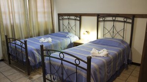 A room with two beds, each with a blue bedspread and white towels. - Villas Tonantzintla (San Andrés Cholula)