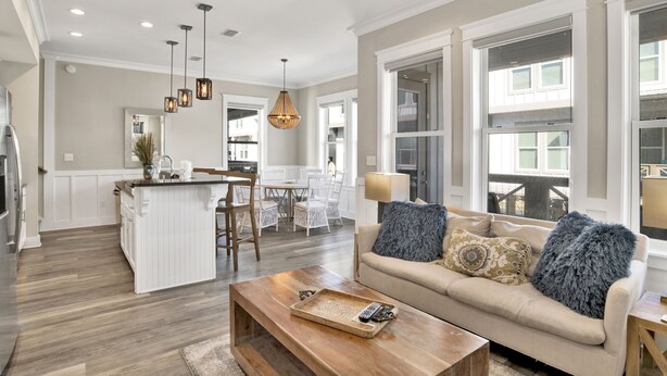 A spacious living area with a large sofa, a wooden coffee table, and a kitchen island.