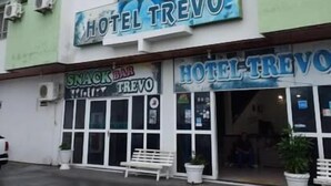 A building with a sign reading "HOTEL TREVO" and a smaller sign for "SNACK BAR TREVO". - Hotel Trevo (Boa Vista)