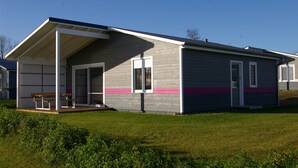 A modern single-story building with a covered porch and a door leading to a garage.
