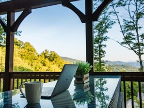 Relax in a serene outdoor setting with a clear view of lush greenery and distant hills.