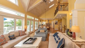 A spacious living area with high ceilings, large windows, and a kitchen in the background. - Deep Creek Escape w/ Dock, Hot Tub & Views (Oakland)