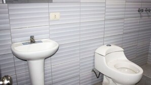 Un baño con un lavamanos blanco y un inodoro.