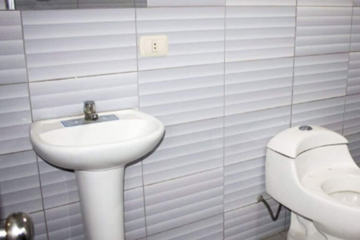A bathroom with a white sink and a toilet.