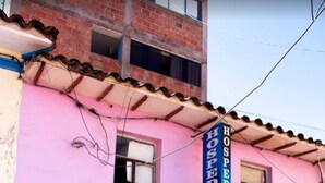 Un edificio rosa con un cartel que dice "HOSPEDAJE SONDO VISTA".